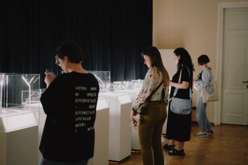 Visitors in front of exhibits on tables.
