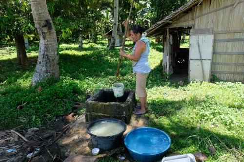 Woman fetching murky water from a well
