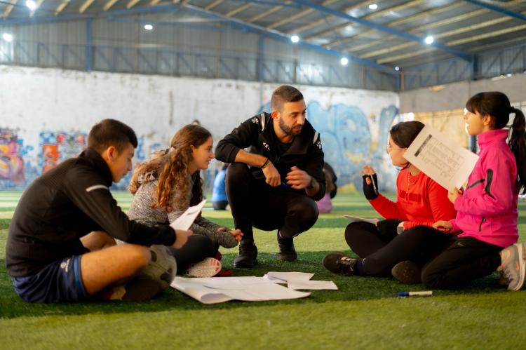 Libanon: Ein Trainer im Projekt "Sports for Peace" unterh&auml;lt sich mit vier jungen Teilnehmenden