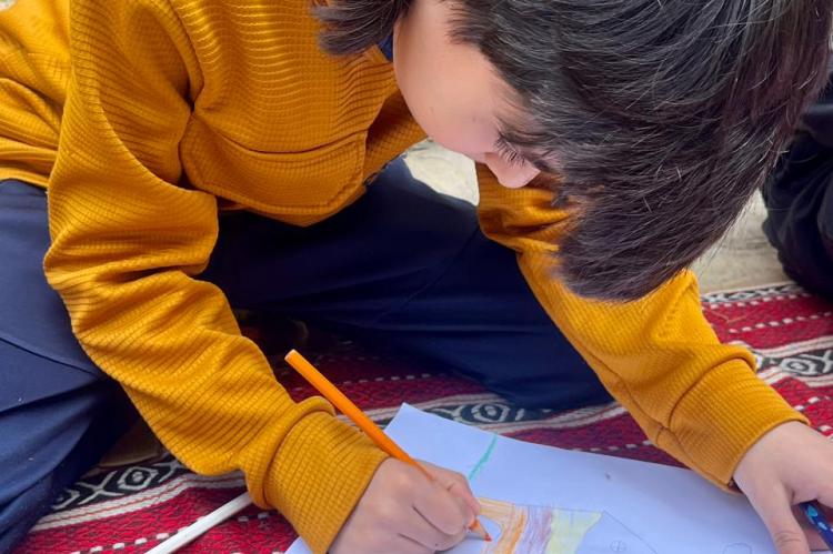 Kind in einem Vertriebenencamp im Libanon beim Malen