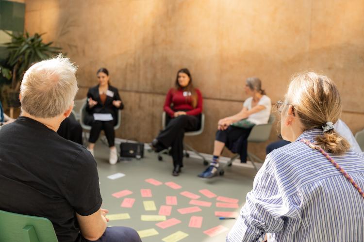 In der Mitte eines Stuhlkreises liegen rote und gelbe Moderationskarten.