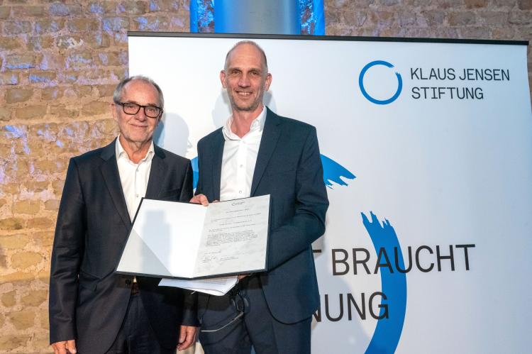 Olivier Knabe (forumZFD’s chair of the executive board) holding the Reconciliation Award 