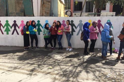 Yound women standing in fron of a painted wall