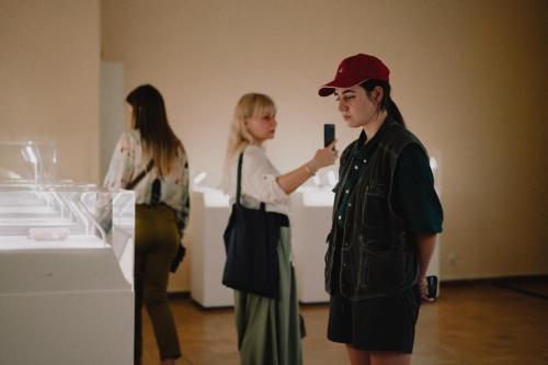 Eine Gruppe von Menschen begutachtet die Ausstellung des War Childhood Museums.