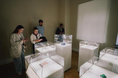 Eine Gruppe von Menschen begutachtet die Ausstellung des War Childhood Museums.