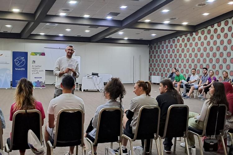 Trainer Nenad Andrić spricht mit Teilnehmenden über Identität