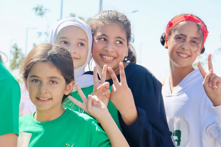 Fröhliche Jugendliche machen das Peace-Zeichen bei einem Marathon in Jordanien