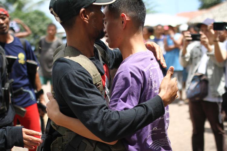 Ein Soldat und ein junger Mann umarmen sich auf den Philippinen