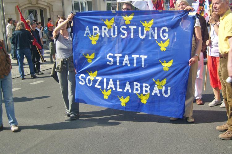 Demonstranten mit Banner "Abrüstung statt Sozialabbau"