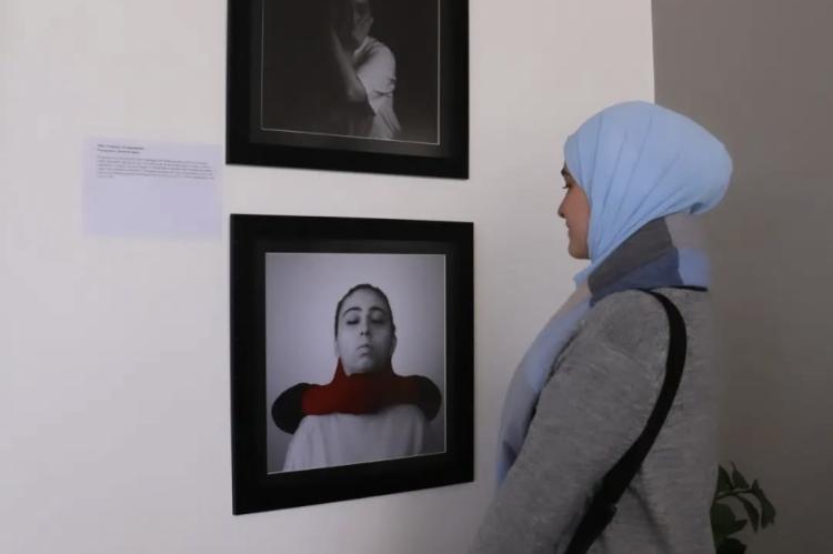 Eine Frau betrachtet eine Ausstellung von Hamida.