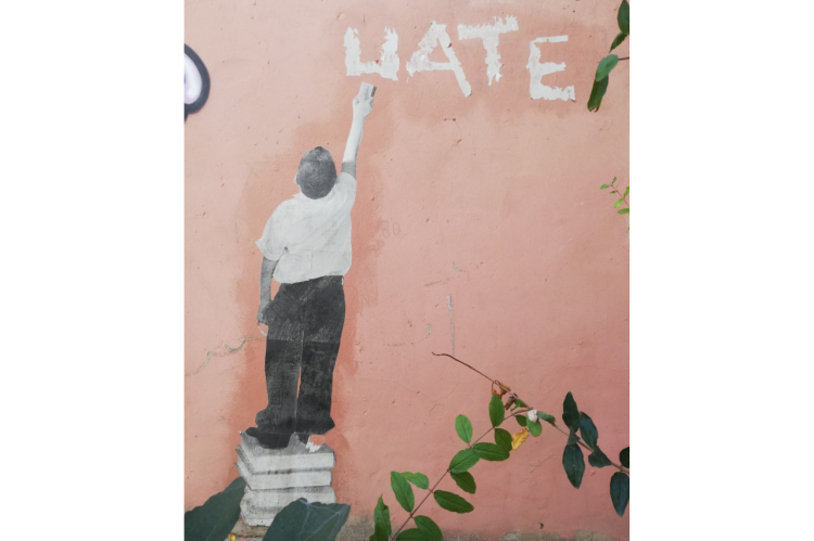 Graffiti aus Beirut, in dem ein Schulkind das Wort "Hate" wegwischt