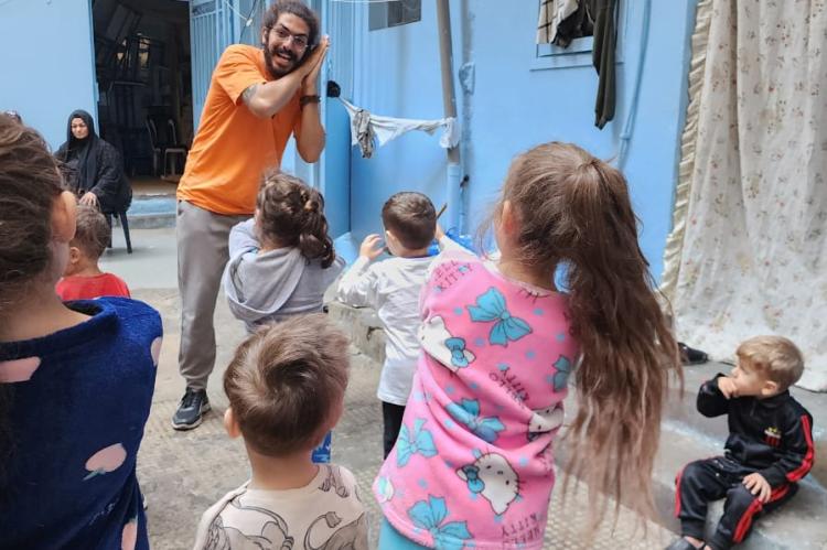 A man plays with a group of children.