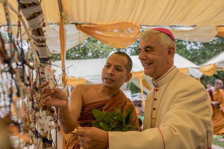 Principal Sovechea Vy and Bishop Figaredo consider the guests' wishes for peace.