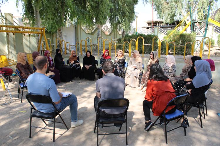 Menschen im Irak sitzen in einem Kreis und lernen sich kennen