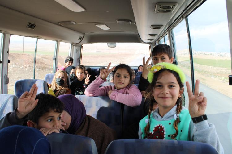 Kinder sitzen im Salam-Bus und lächeln freudig in die Kamera.