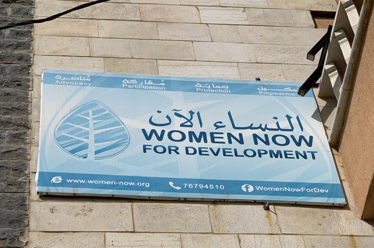 Blue sign outside the centre, reading 'Women Now for Development' in English and Arabic