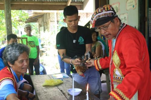 Indigenous youth assist their traditional leader in a ritual
