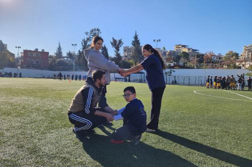 A coach with kids in the field