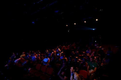 Gespannt beobachtet das Publikum eine Theaterinszenierung.