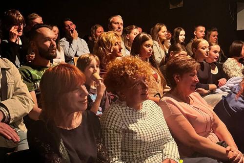 Gespannt beobachtet das Publikum eine Theaterinszenierung.