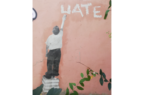 Graffiti aus Beirut, in dem ein Schulkind das Wort "Hate" wegwischt