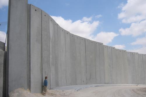 Person standing in front of a high concrete wall