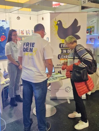 Ein Standbesucherin informiert sich während der Frankfurter Buchmesse über die Arbeit von Pro Peace