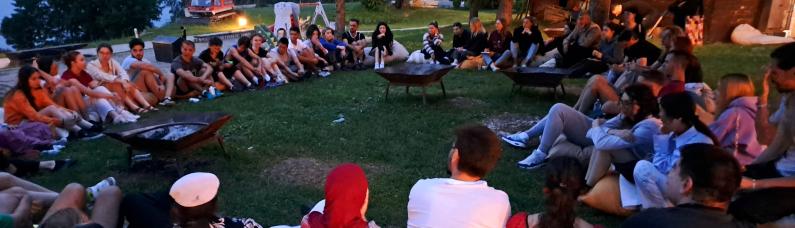 Leute sitzen um Lagerfeuer