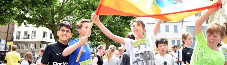 Gemeinsam aktiv für Frieden Jugendliche halten bei einem Friedenslauf von Pro Peace eine PACE-Flagge hoch