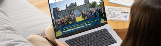 Eine Frau liest den Pro Peace Gesch&auml;ftsbericht 2023 auf ihrem Laptop