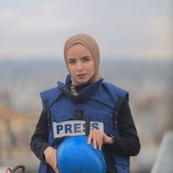 Ma'ather poses in a Security West labeled "PRESS"