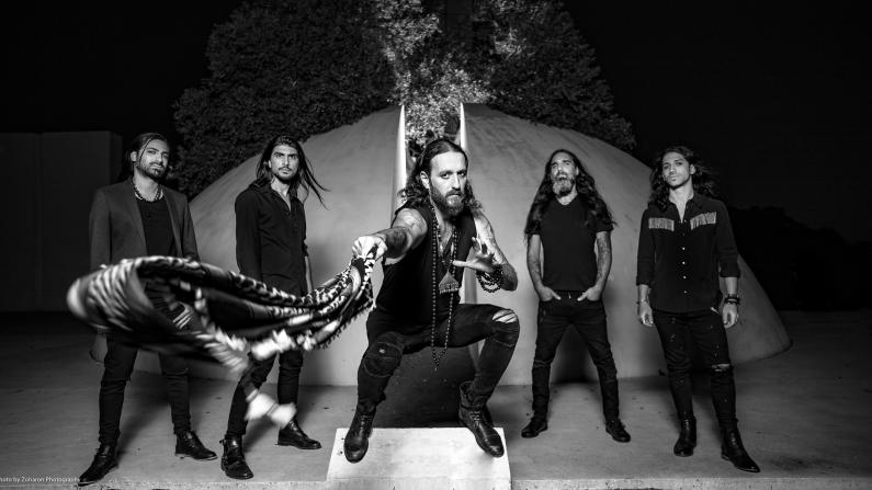Die Band Orphaned Land hat sich um ihren auf einen Thron sitzenden Sänger Kobi Fahrhi versammelt.