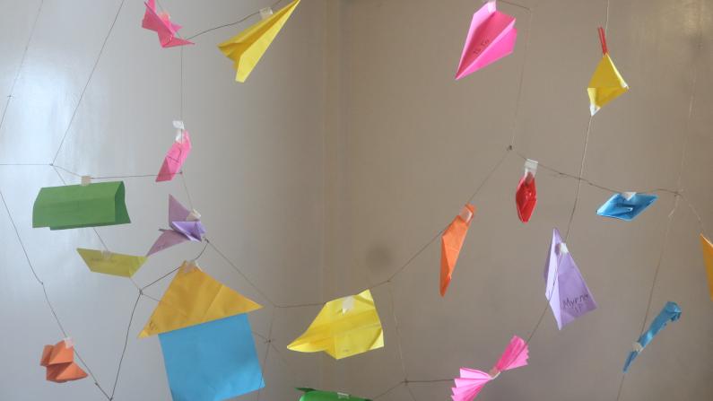 Folded pieces of paper held together by strings