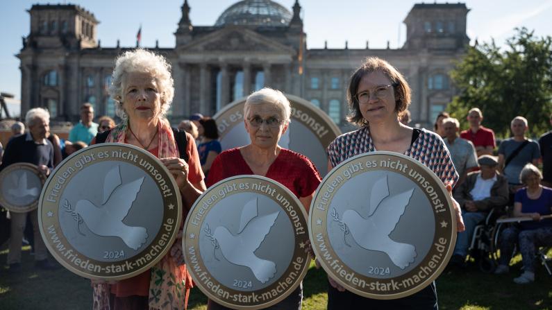 Frieden gibt es nicht umsonst Drei Aktivistinnen bei der Protestaktion "Frieden gibt es nicht umsonst"