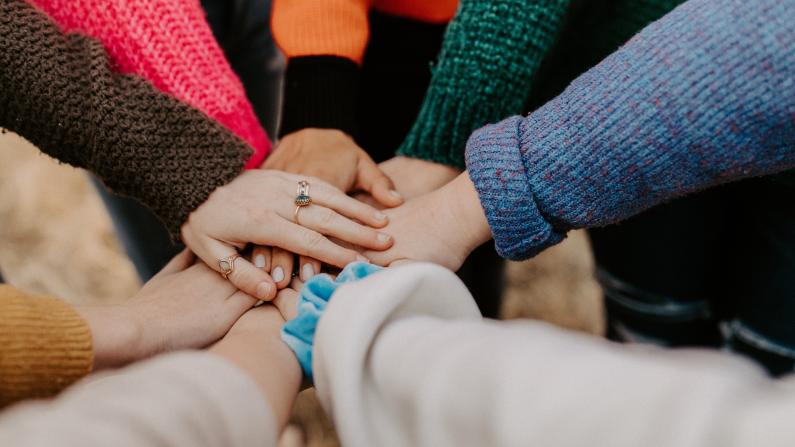 Eine Gruppe von Menschen fasst sich an den Händen