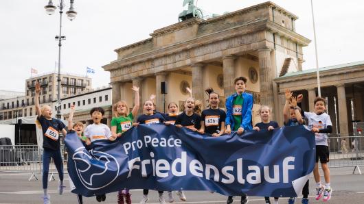 Teilnehmende des Berliner Friedenslaufs 2026 vor dem Brandenburger Tor