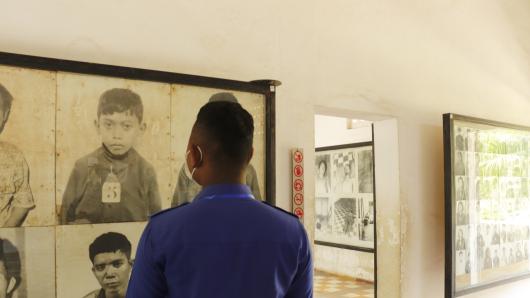 Ein junger Mann betrachtet eine Ausstellung in Tuol Sleng, dem ehemaligen Foltergef&auml;ngnis der Roten Khmer 