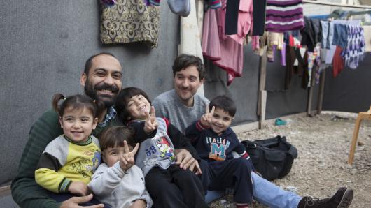 Father and kids laughing in a refugee camp in Akkar 