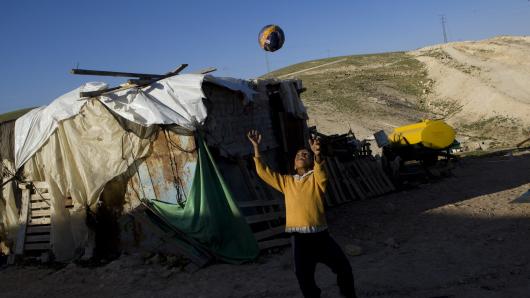 Ein Junge spielt Ball vor seinem Haus in Khan al Ahmar, Pal&auml;stina