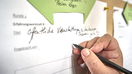 Anmeldung f&uuml;r den Workshop - im Bild von Hand, hier online