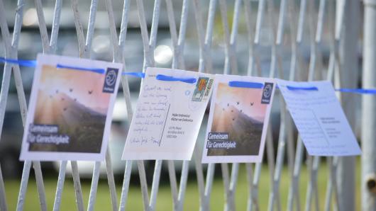 Postkarten, adressiert an die M&uuml;tter von Srebrenica, h&auml;ngen aufgereiht an einem Zaun.