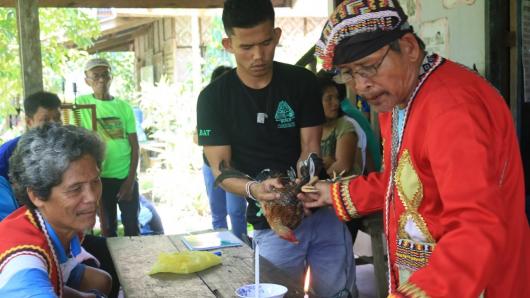 Indigenous youth assist their traditional leader in a ritual