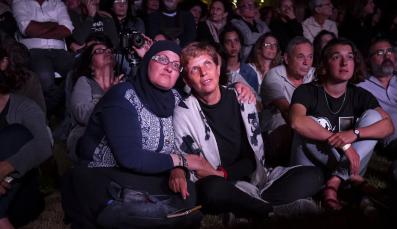 Palestinian and Israeli women mourning together, arm in arm, during the Joint Memorial Day Ceremony