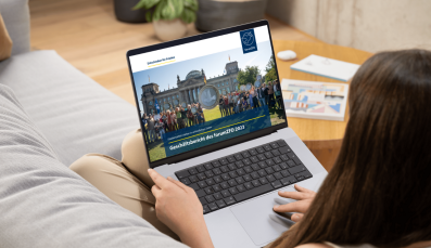 Eine Frau liest den Pro Peace Geschäftsbericht 2023 auf ihrem Laptop