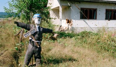 Eine Vogelscheuche, die als Peace Keeper der Vereinten Nationen verkleidet ist, vor einem Haus mit Einschusslöchern in der Stadt Kostajnica an der Grenze zu Kroatien in Nordbosnien.