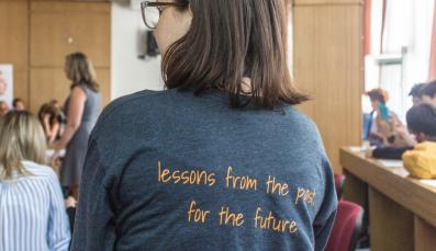 Eine Frau, auf deren T-Shirt "Lessons from the past for the future" steht.