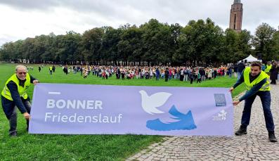Helfer halten Banner zum 17. Bonner Friedenslauf