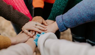 Eine Gruppe von Menschen fasst sich an den Händen