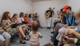 Teenagers, parents, and facilitators continue a music session in an air raid shelter during the Kid Friendly Summer Lab in Odesa, Ukraine.