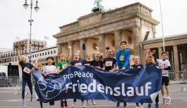 Teilnehmende des Berliner Friedenslaufs 2026 vor dem Brandenburger Tor